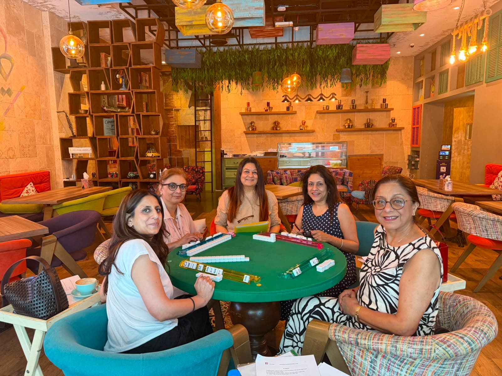 Players seated around a Mahjong table during guided practice in Dubai