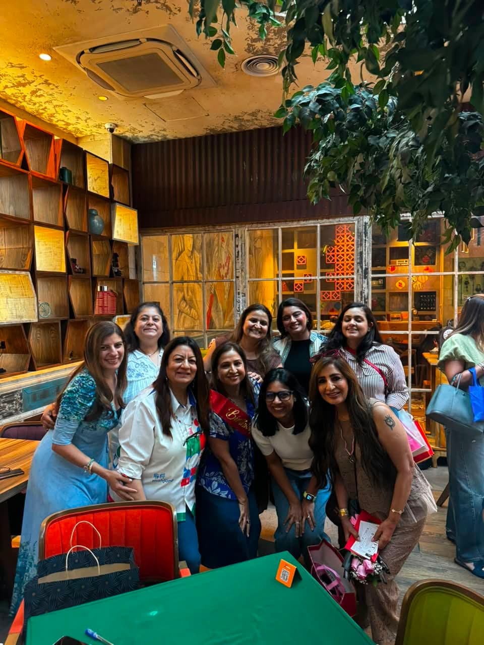 Mahjong players gathered for a group photo at a Dubai cafe table