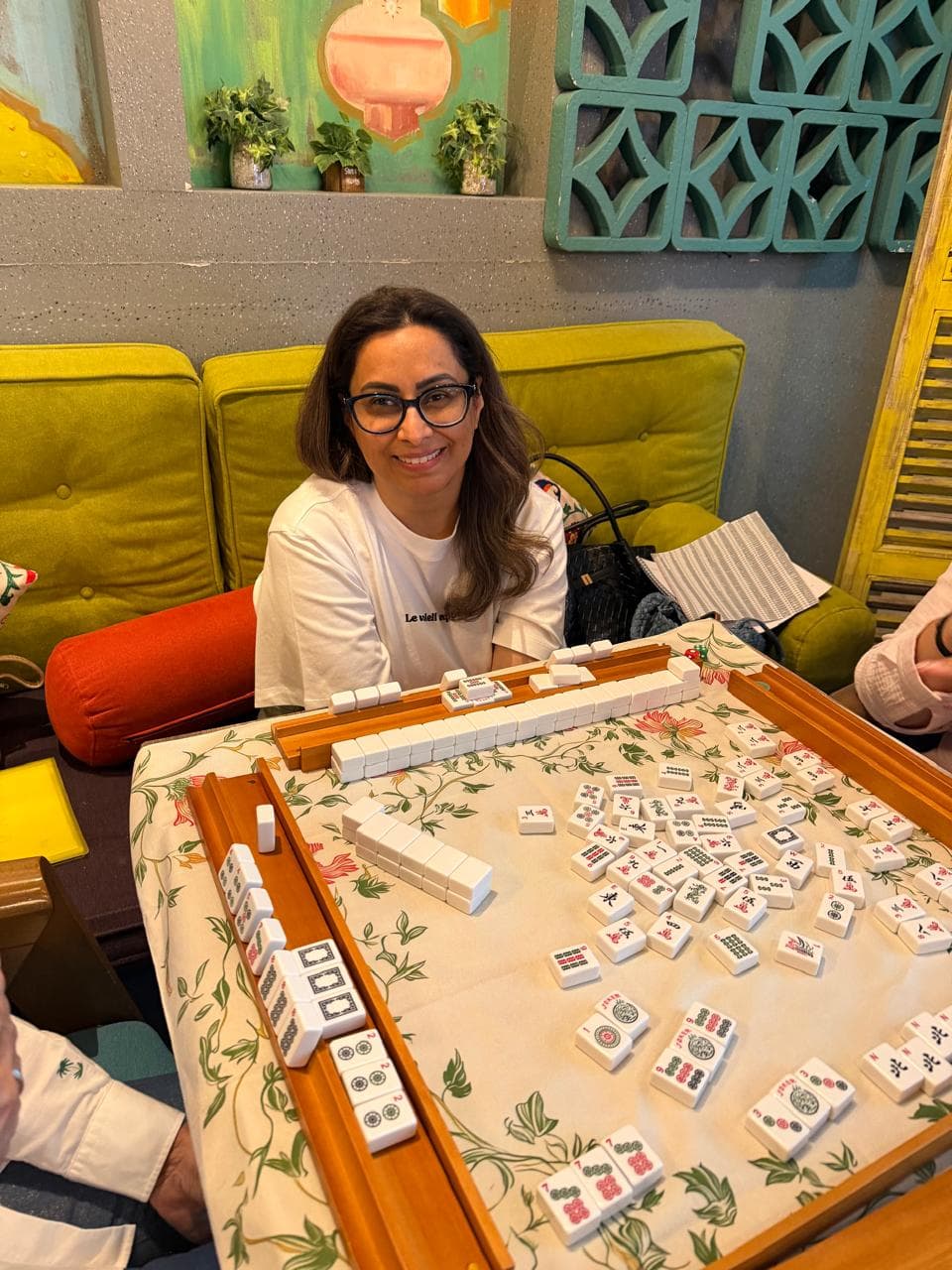 Mahjong score sheet and pen beside a Dubai class table