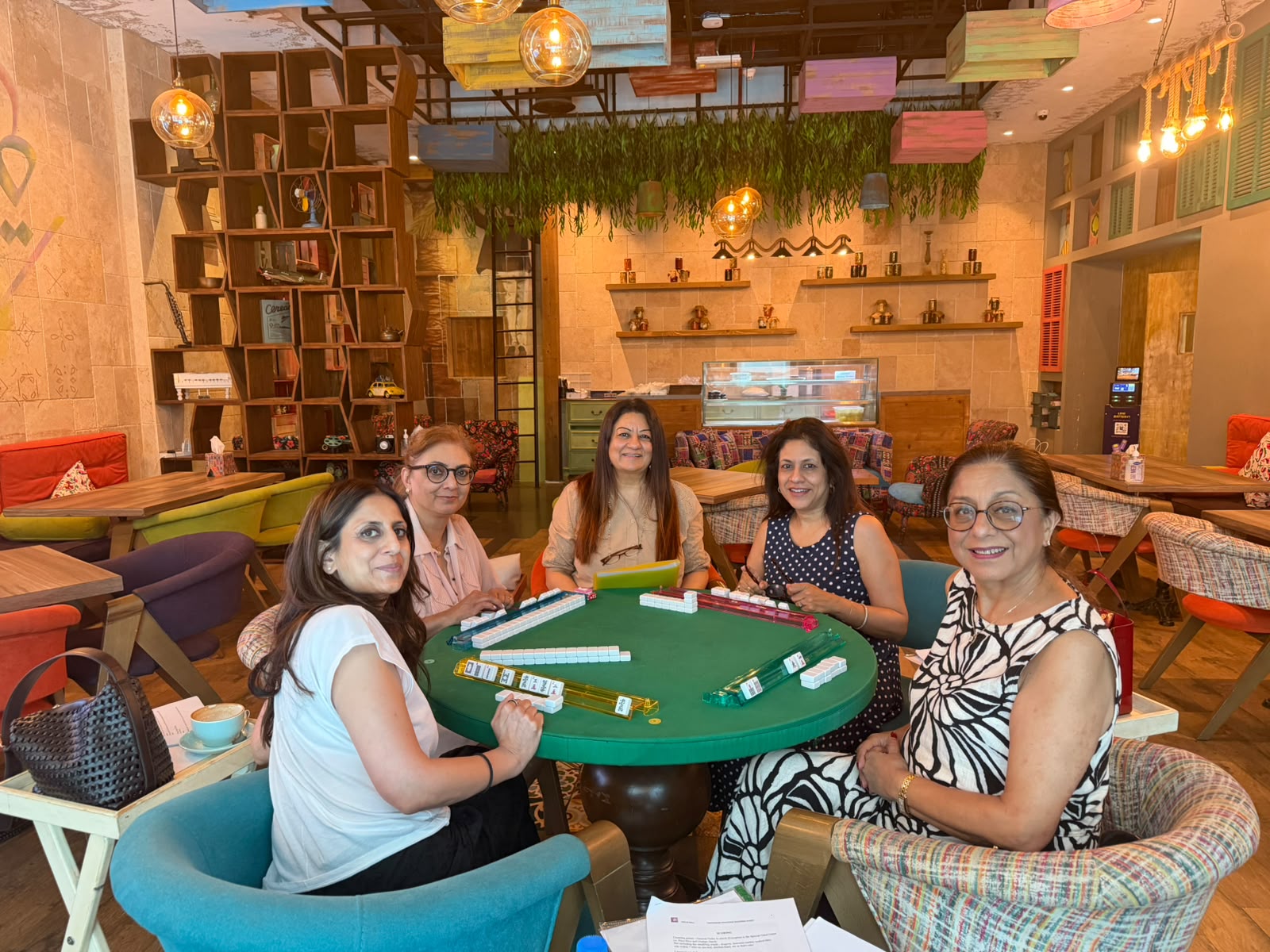 Players seated around a Mahjong table during guided practice in Dubai