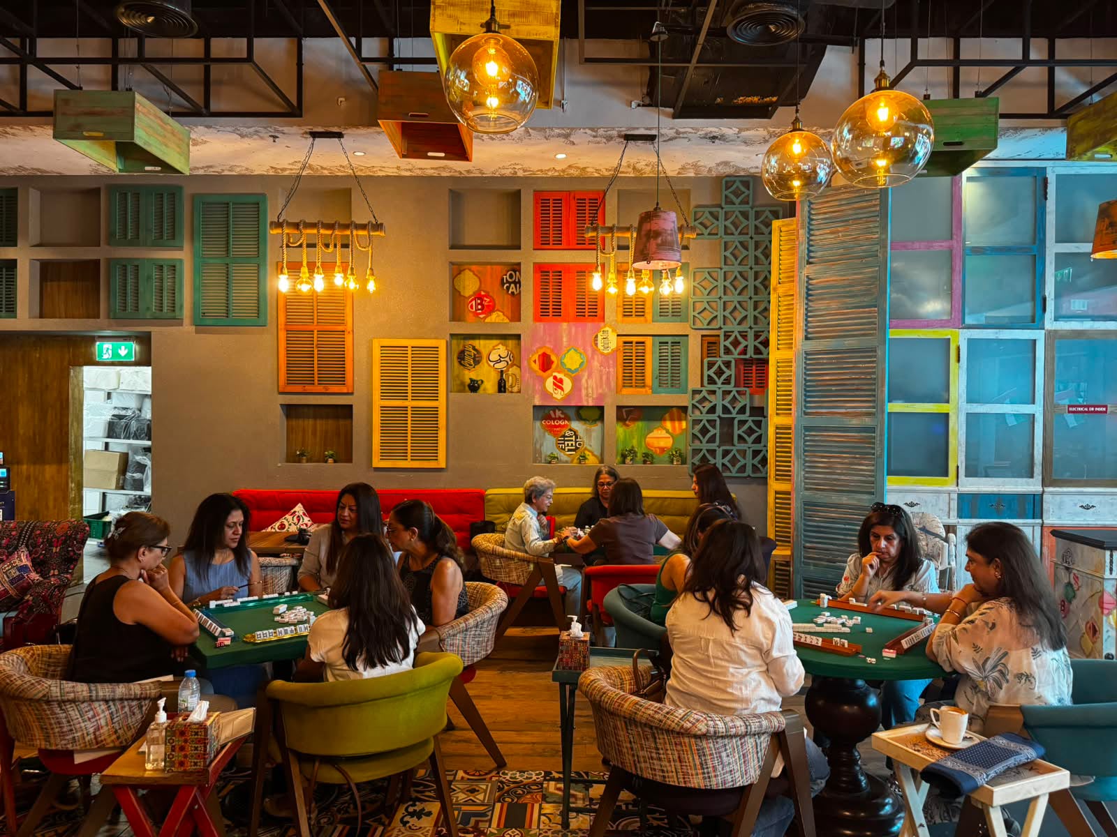 Multiple Mahjong tables playing in a colorful Dubai cafe venue
