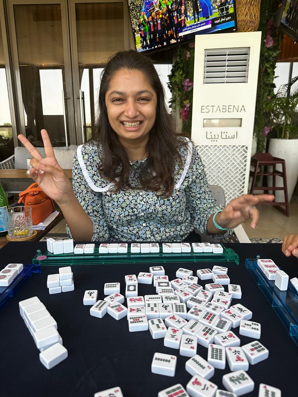 Smiling student at a Mahjong lesson table